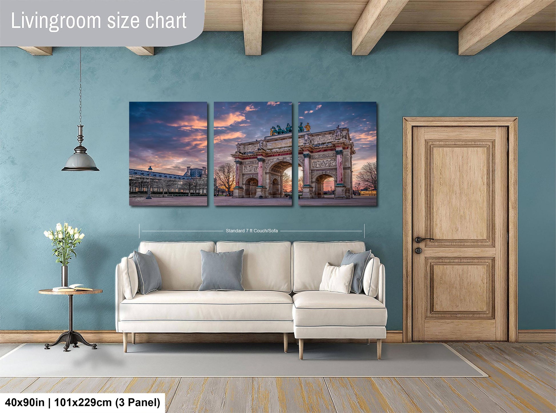 The image is a living room with a large wall art piece depicting the Arc de Triomphe in Paris, France. The wall art is divided into three panels, each showing different angles of the iconic monument. The living room has a white sofa and a wooden door, creating a cozy and inviting atmosphere.