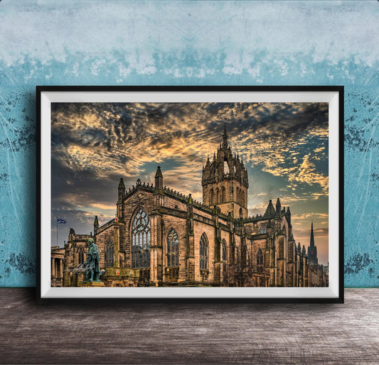 A framed photograph of a large, ornate cathedral with a castle-like structure, set against a dramatic sky with clouds and a sunset.