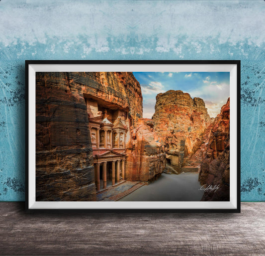 a large, ancient stone structure carved into a cliff face, with a river flowing through the carved grooves.