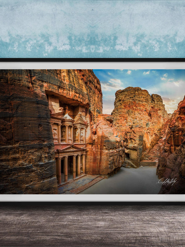 a large, ancient stone structure carved into a cliff face, with a river flowing through the carved grooves.
