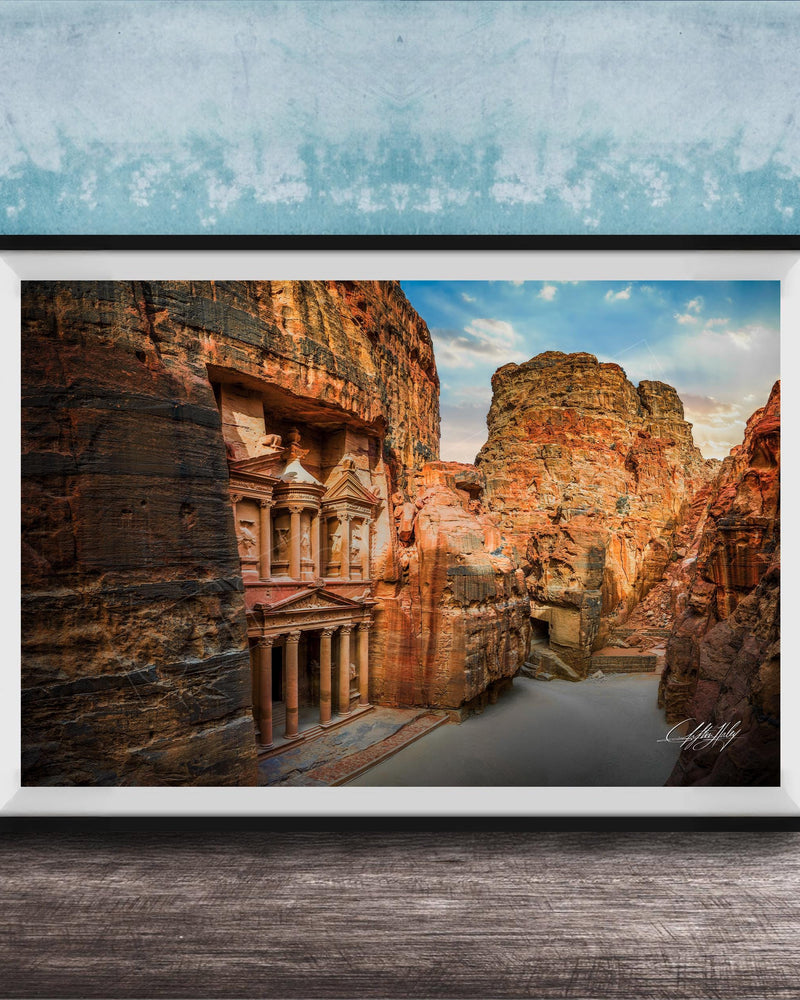 a large, ancient stone structure carved into a cliff face, with a river flowing through the carved grooves.