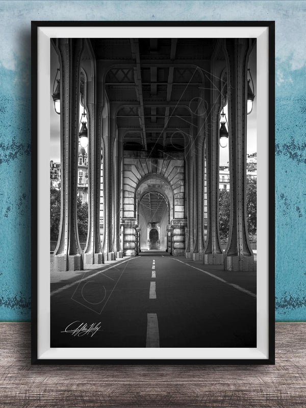 A black and white photograph of a long, narrow hallway with tall columns and arches, leading to a doorway at the end. The hallway appears to be part of a larger architectural structure, possibly a building or a church.