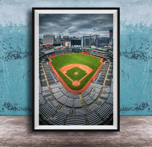A framed photograph of a baseball stadium with a city skyline in the background.