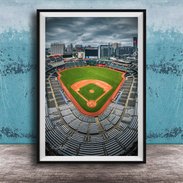 A framed photograph of a baseball stadium with a city skyline in the background.