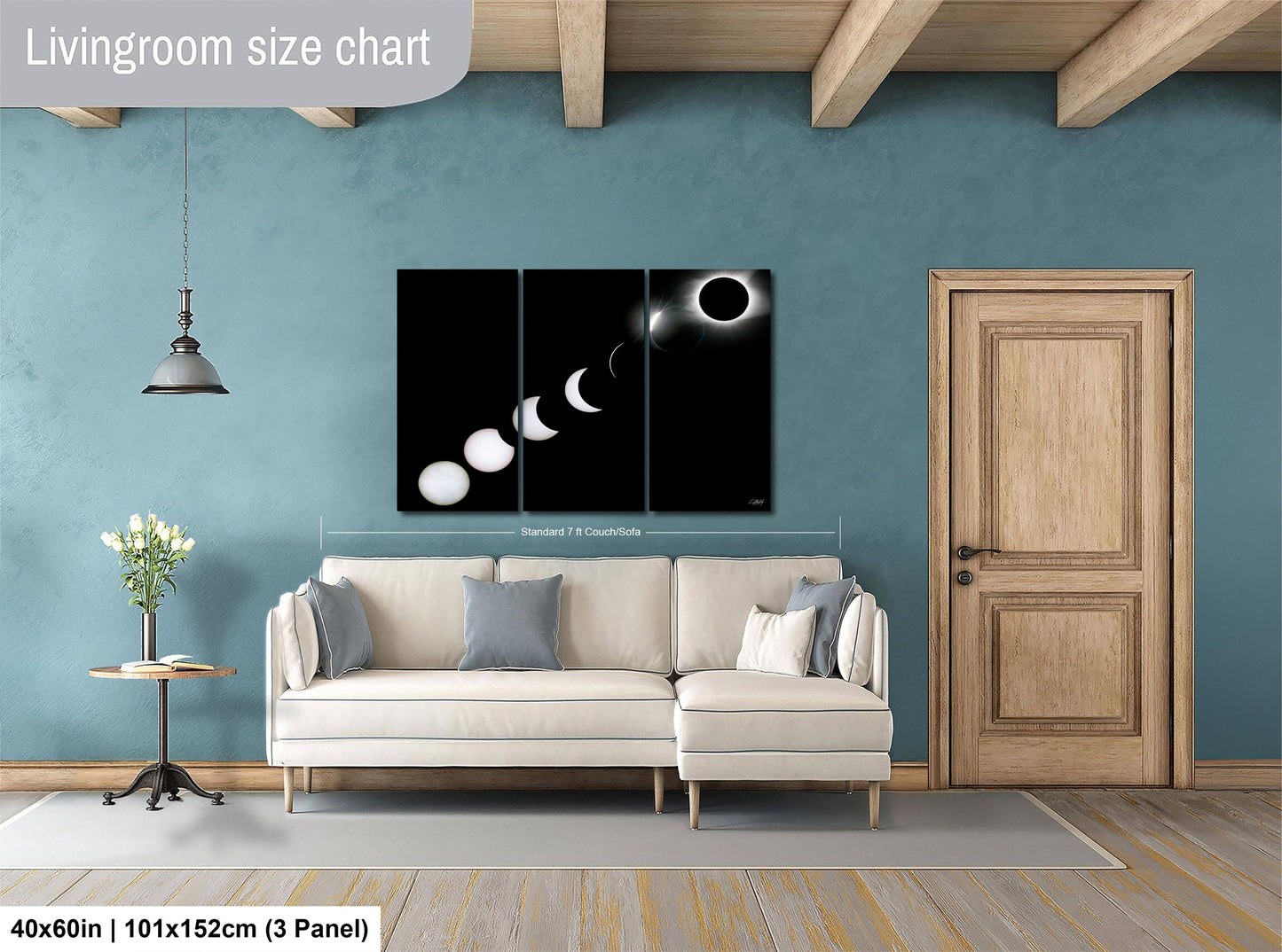 The image is a living room with a white sofa, a wooden door, and a large black and white solar eclipse painting on the wall.