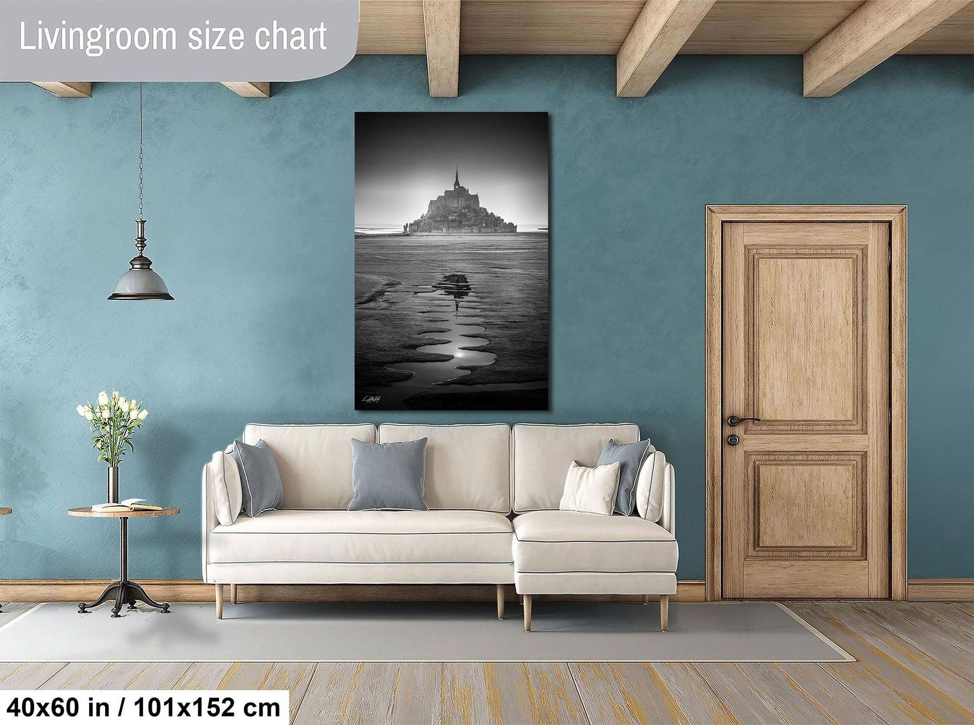 a living room with a large black and white photograph of a castle or palace in the background, hanging on the wall above a white sofa.