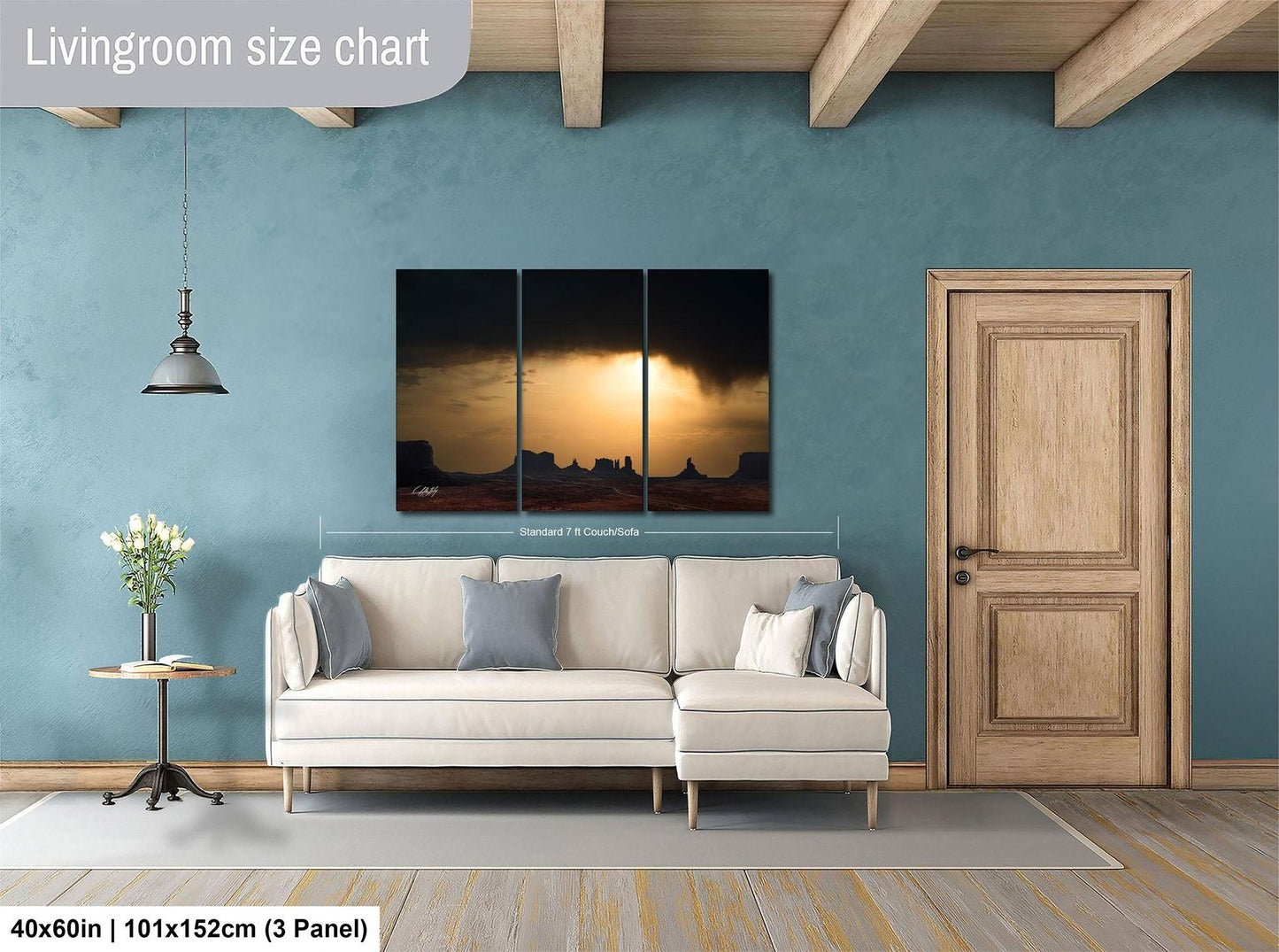 The image is a living room with a white sofa, a wooden door, and a painting of a desert landscape on the wall.