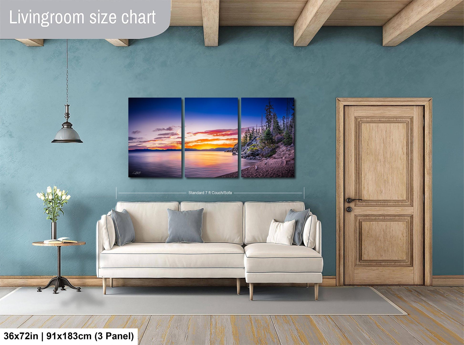 The image is a living room with a large wall art depicting a serene landscape with a sunset over a body of water. The wall art is divided into three panels, each capturing different aspects of the scene. The living room has a white sofa and a wooden door, creating a cozy and inviting atmosphere.