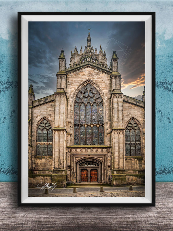 A framed photograph of a Gothic cathedral with a large rose window and a tall spire, set against a cloudy sky.