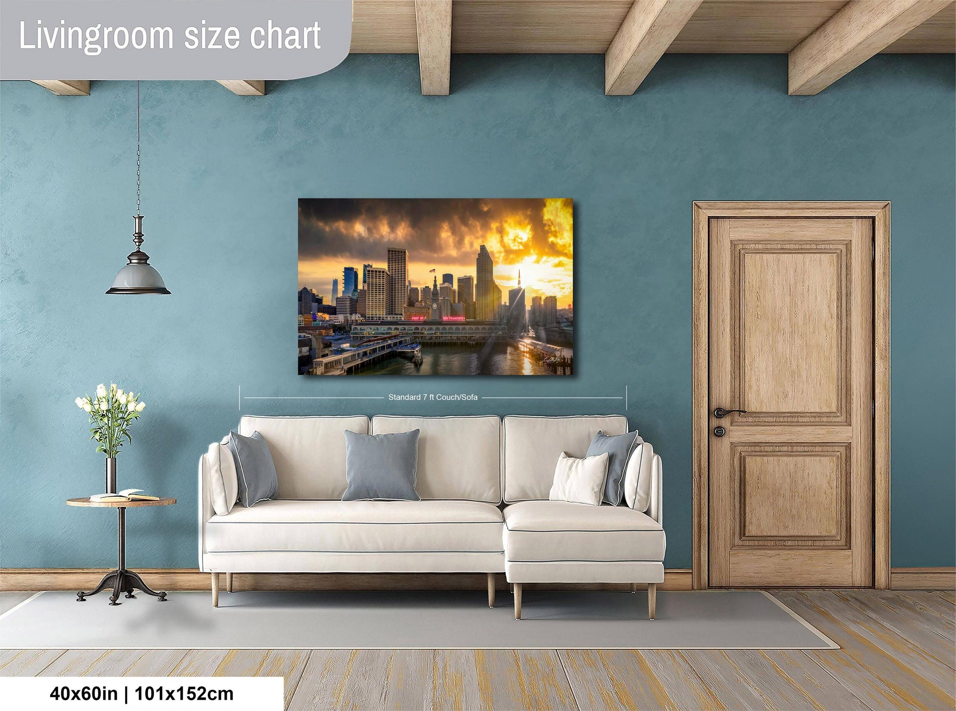 a living room with a large city skyline painting hanging on the wall. The painting features a sunset over the city skyline, creating a warm and inviting atmosphere. The living room is furnished with a white sofa and a wooden door, providing a cozy and comfortable space. The painting is approximately 40 inches wide and 115 centimeters tall, making it a prominent feature in the room.