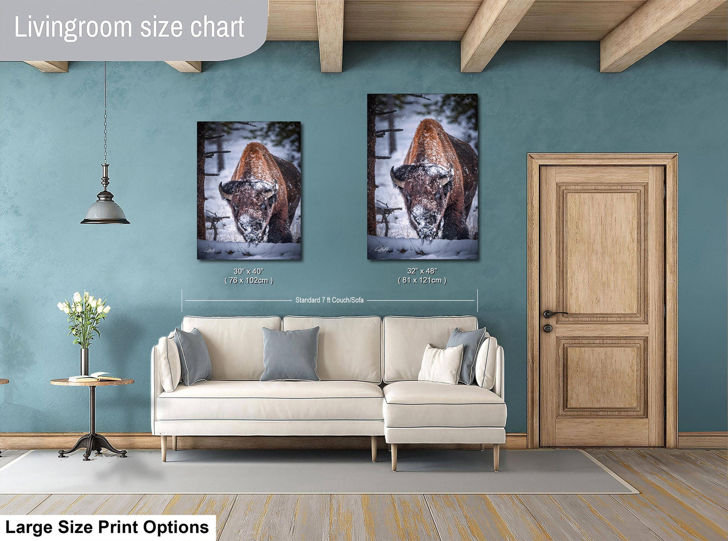 a living room with a white sofa, a wooden door, and two framed photographs of a brown animal, possibly a deer, hanging on the wall.