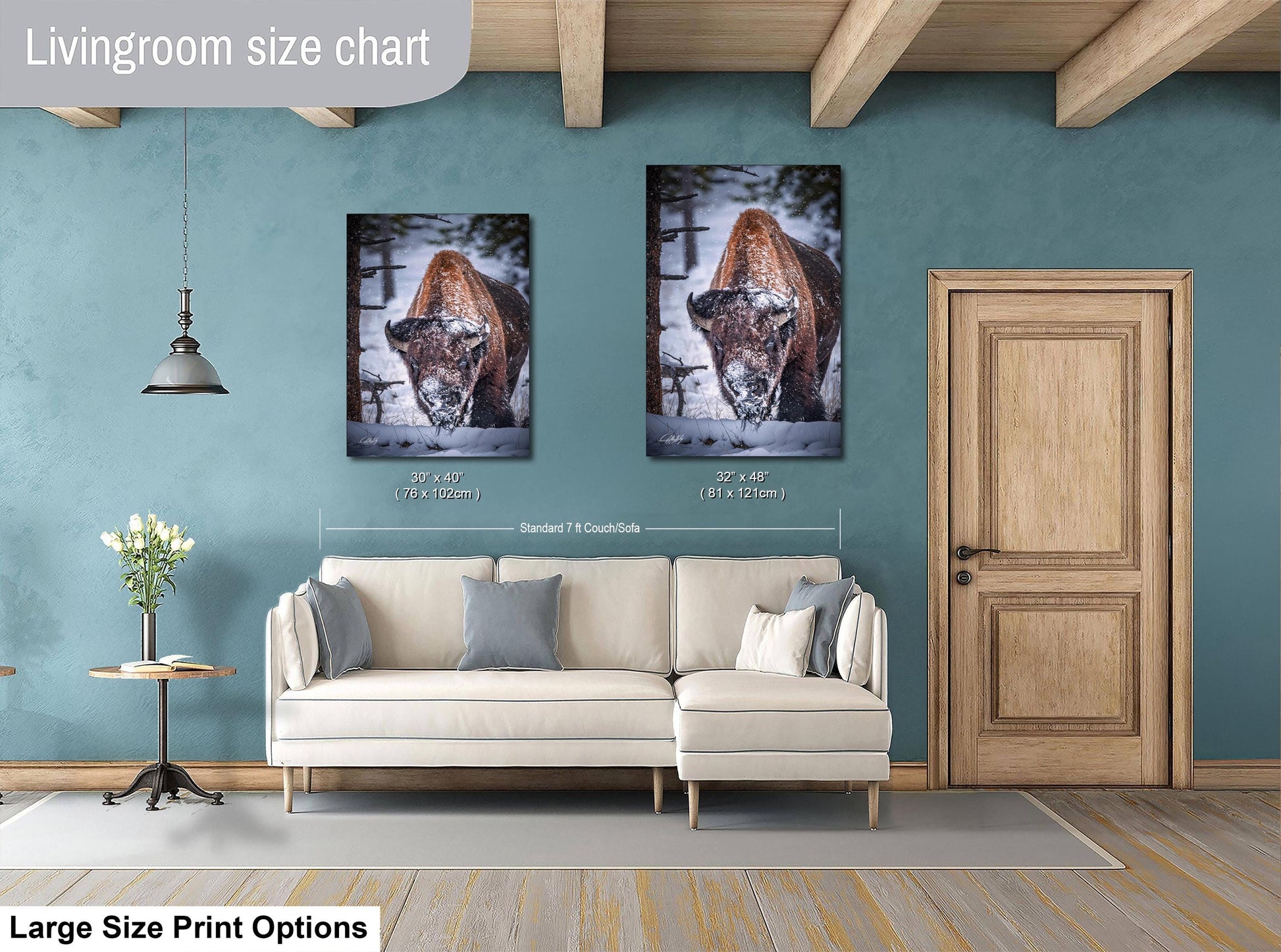 a living room with a white sofa, a wooden door, and two framed photographs of a brown animal, possibly a deer, hanging on the wall.