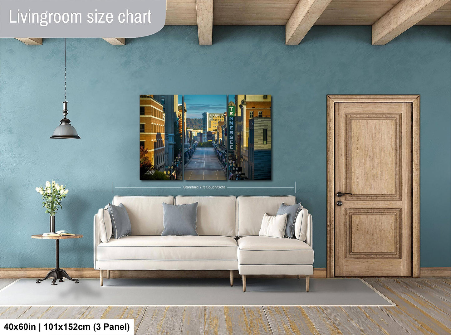 a living room with a large painting of a cityscape hanging on the wall. The painting is framed and appears to be a high-quality, professional-grade artwork. The room has a white sofa and a wooden door, creating a modern and stylish interior design.