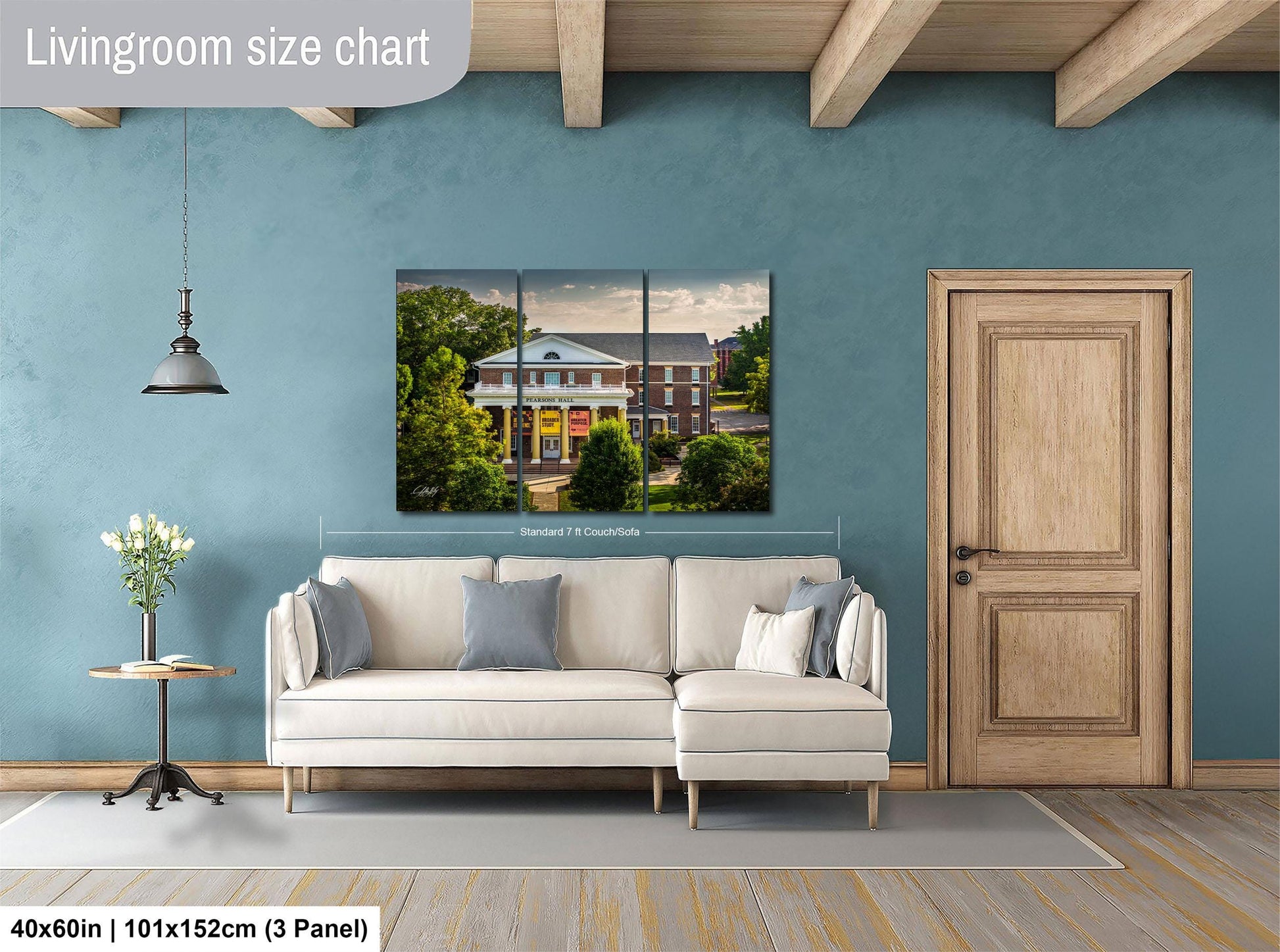 The image is a living room with a large white sofa, a wooden door, and a painting of a building on the wall.