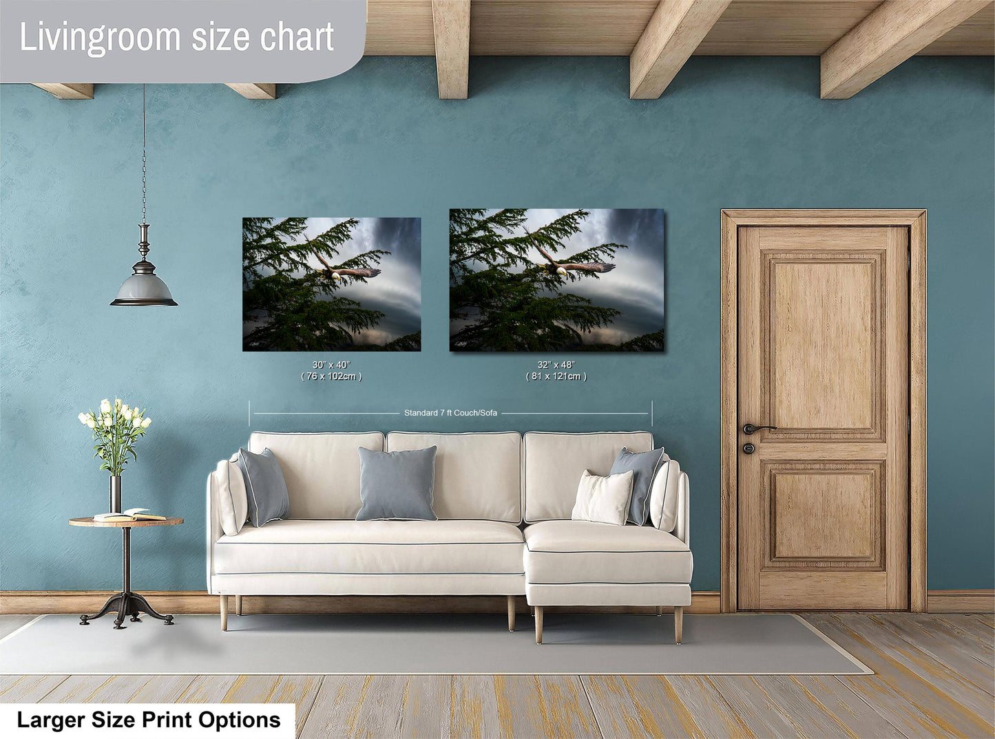 a living room with a white sofa, a wooden door, and two framed landscape photographs hanging on the wall.