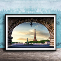 the Eiffel Tower, a famous landmark in Paris, France, captured through an archway. The photograph is framed and displayed on a wooden surface, creating a visually appealing composition.