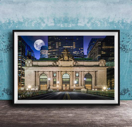 A framed photograph of the Grand Central Terminal in New York City at night, with the iconic building illuminated and a full moon visible in the sky.