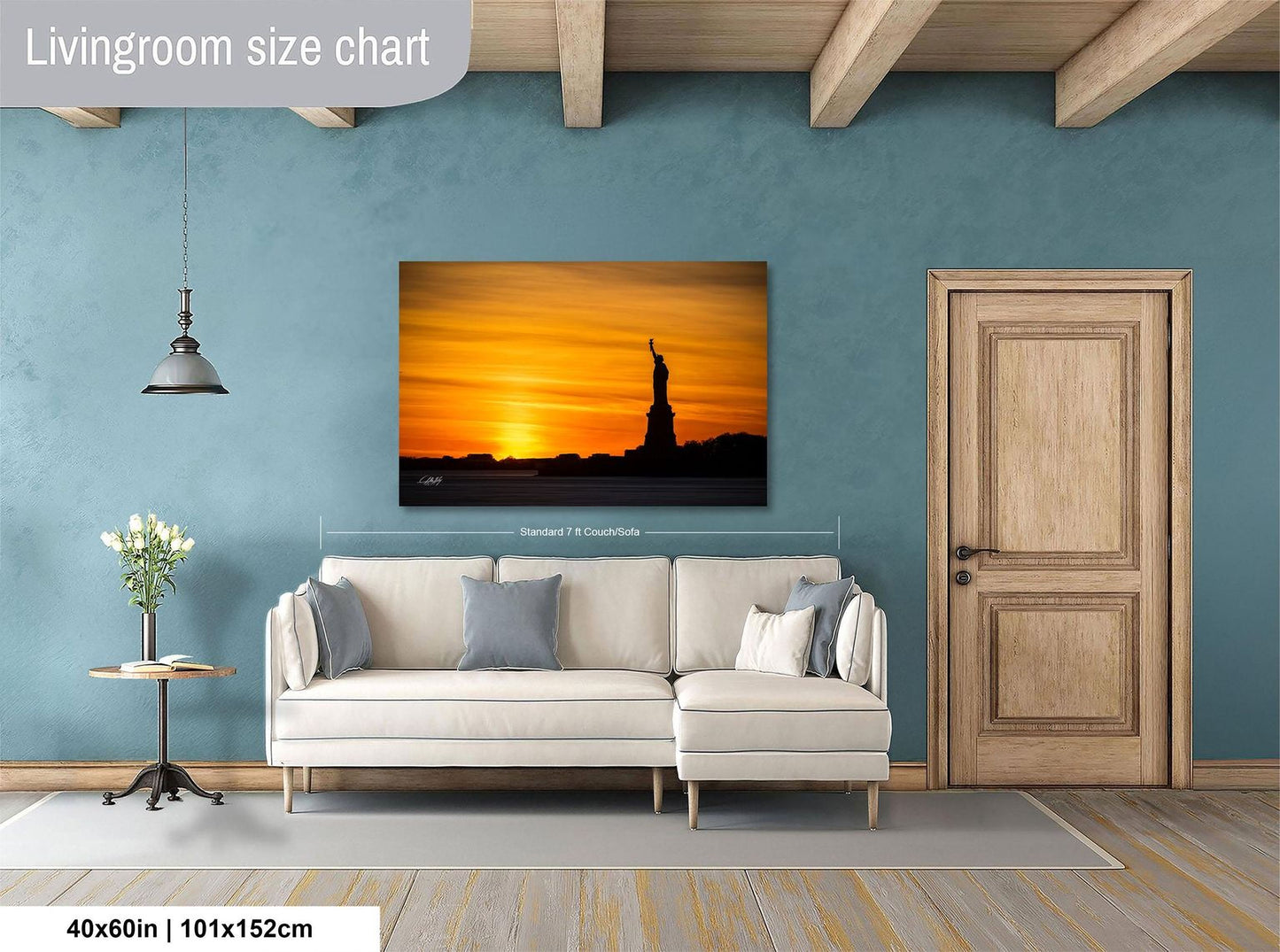 a living room with a large wall-mounted painting of the Statue of Liberty in the background, a white sofa, a wooden door, and a small table with a vase of flowers.