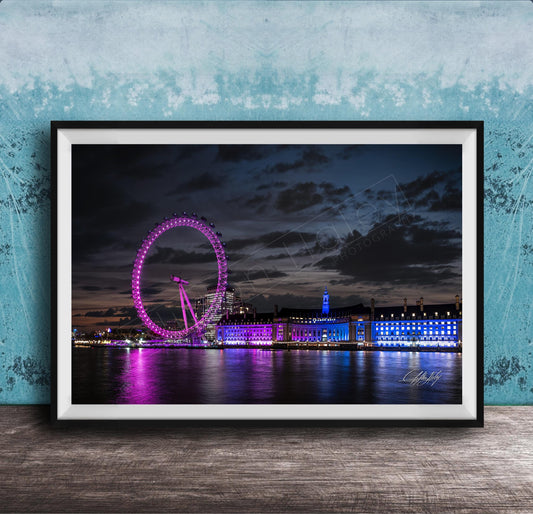 A large Ferris wheel illuminated in purple and blue lights stands against a dark sky, with a city skyline in the background.