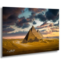 the iconic pyramids of Giza in Egypt, with dramatic clouds and a vibrant sunset sky in the background.