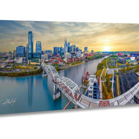 Nashville skyline drone print, aerial view of Cumberland River, Nashville pedestrian bridge wall art, Titans stadium sunset photo, Batman Building skyline print, Music City photography wall decor, Tennessee cityscape metal print, downtown Nashville at golden hour, autumn skyline photo Nashville, faith inspired city wall art, Christian drone photographer print, sunset worship skyline art, modern Nashville wall piece, drone cityscape faith based print, Nashville art for living room