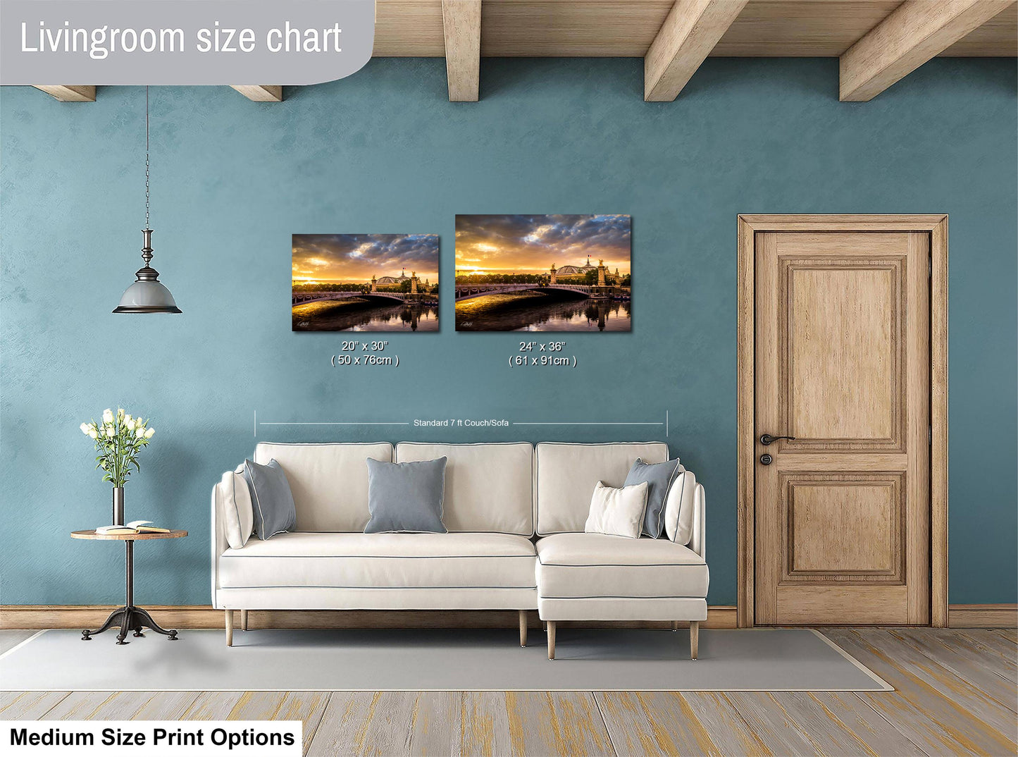 a living room with a white sofa, a wooden door, and a painting of a sunset over a body of water. The painting is hung on the wall above the sofa, and the sofa is positioned in front of the painting.