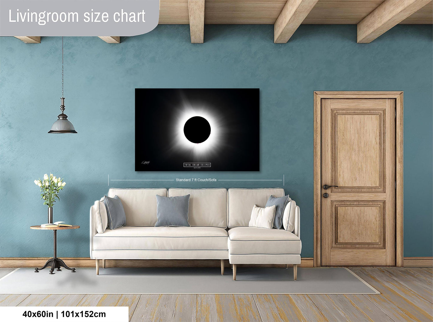 a living room with a large white sofa, a wooden door, and a framed image of the solar eclipse on the wall.