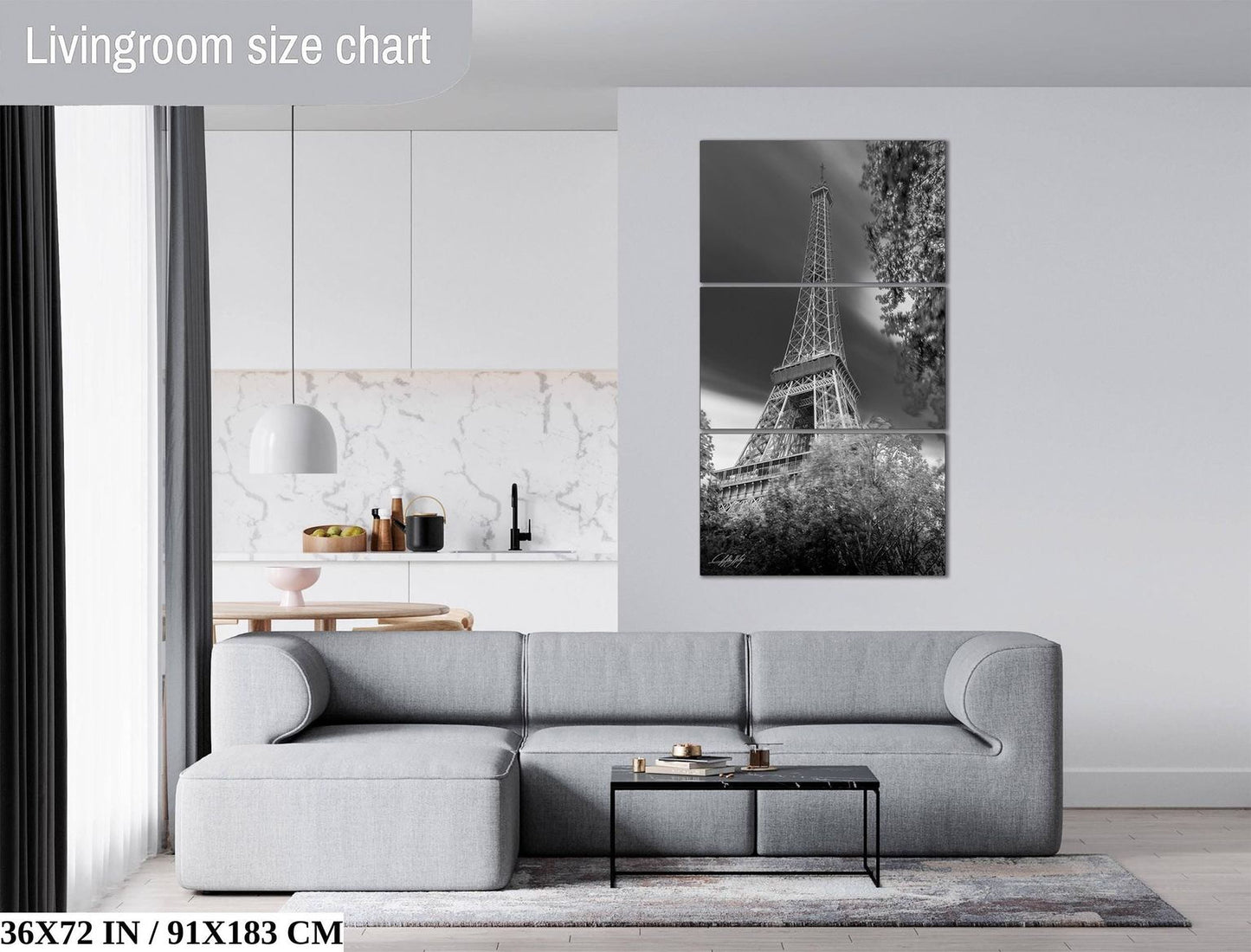 The image is a modern living room with a gray sectional sofa, a coffee table, and a large black and white photograph of the Eiffel Tower on the wall.