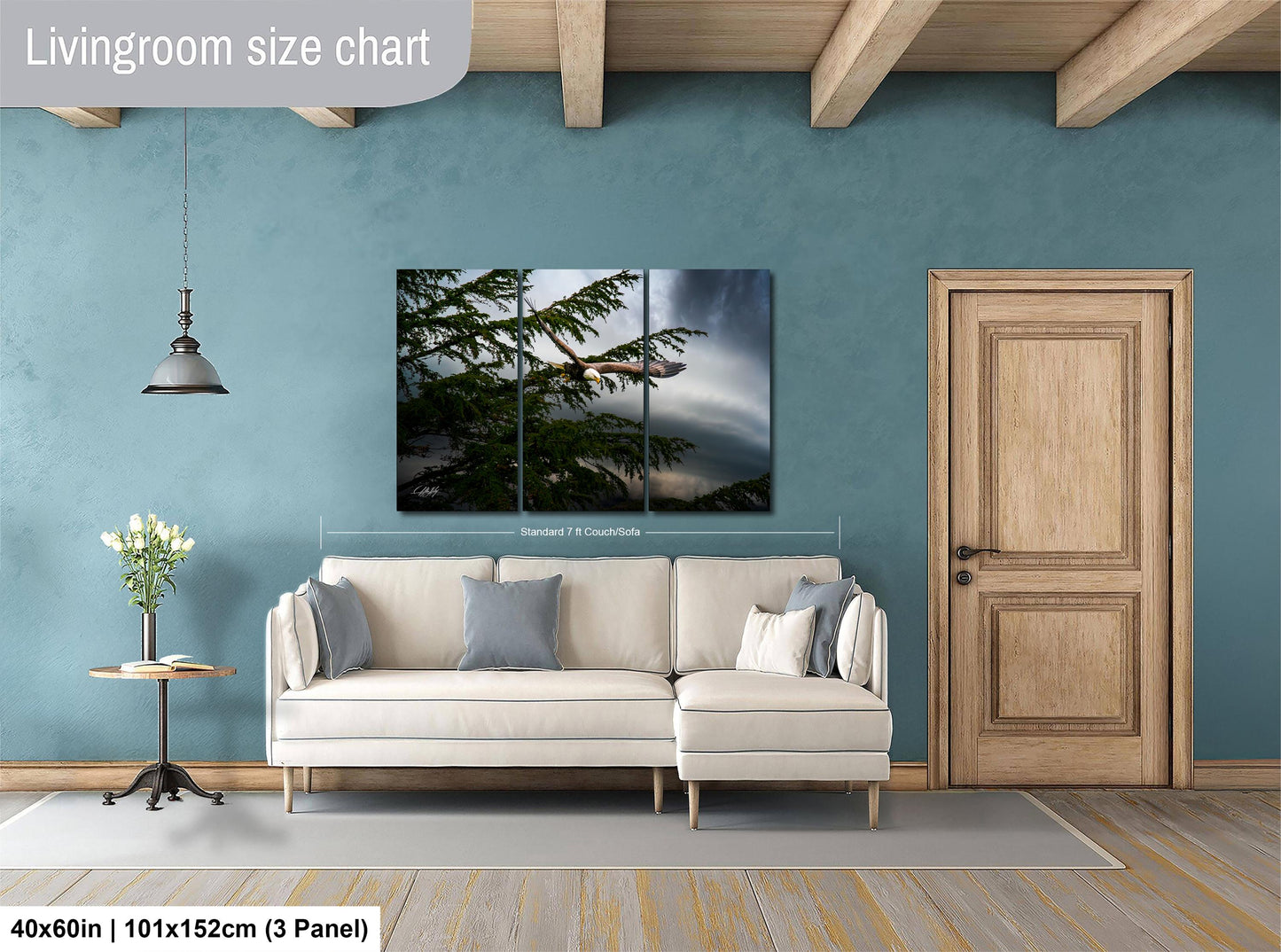 The image is a living room with a white sofa, a wooden door, and a painting of a tree on the wall.