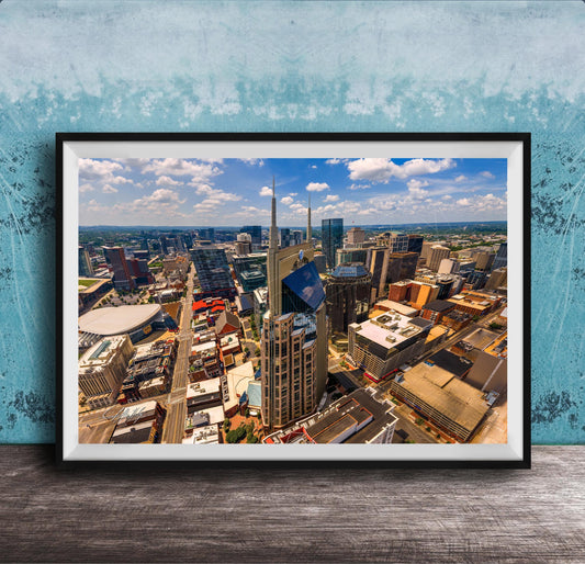 The image is a framed aerial view of a bustling city, showcasing a variety of tall buildings and skyscrapers.