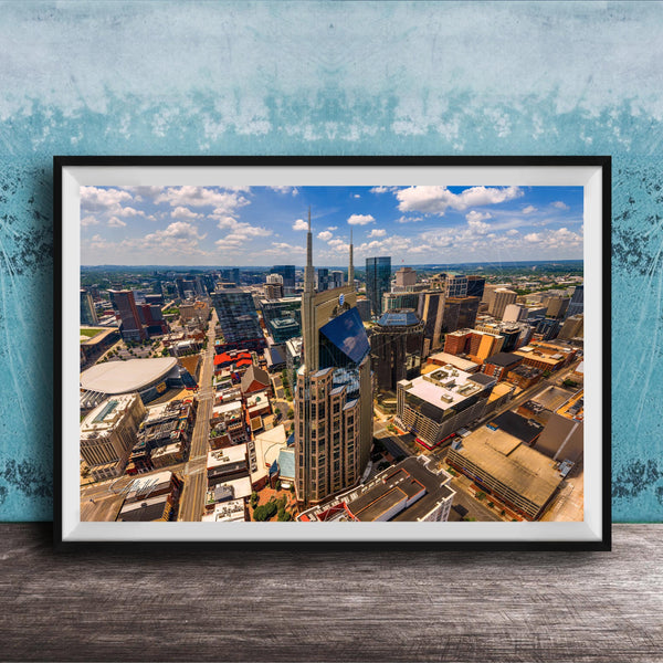 The image is a framed aerial view of a bustling city, showcasing a variety of tall buildings and skyscrapers.