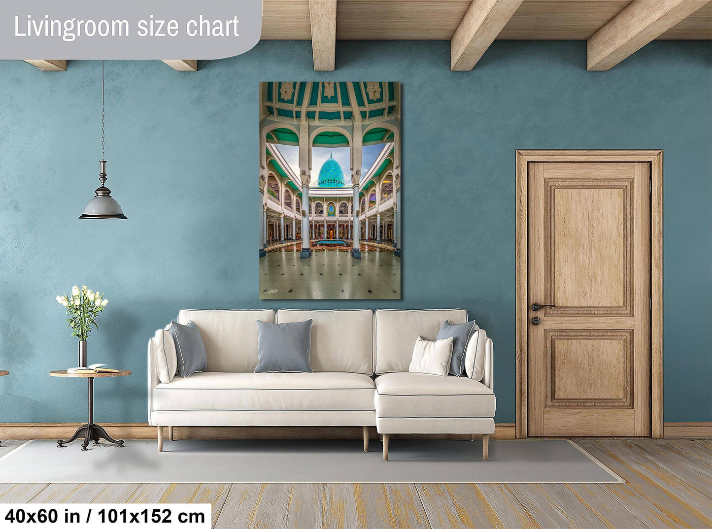 a living room with a large white sofa, a wooden door, and a painting of a grand architectural structure hanging on the wall.