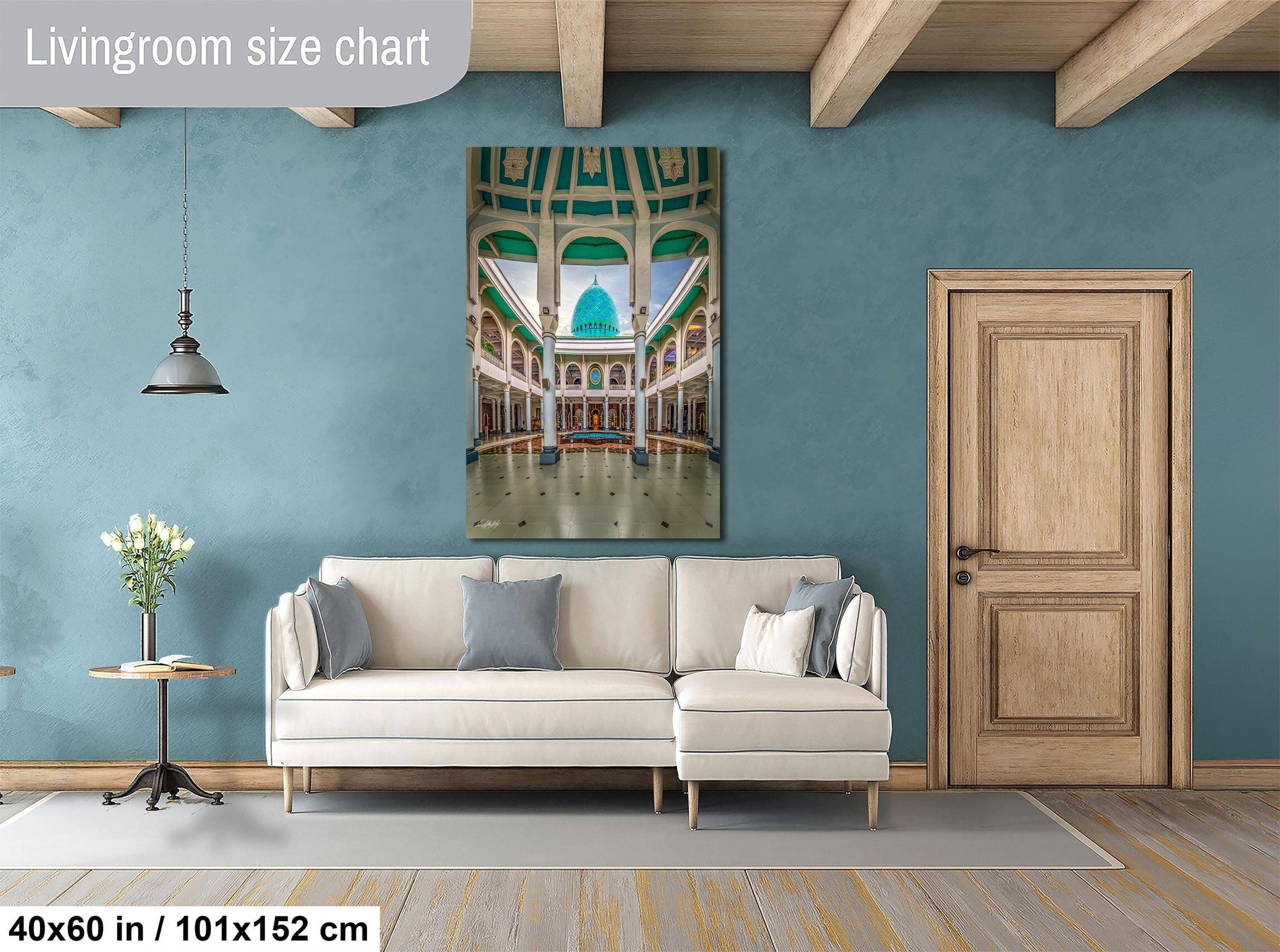 a living room with a large white sofa, a wooden door, and a painting of a grand architectural structure hanging on the wall.