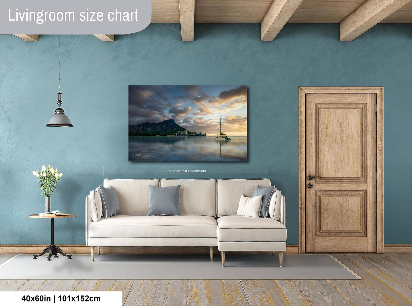 a living room with a large painting of a serene landscape hanging on the wall, featuring a boat on a lake under a cloudy sky. The painting is framed and measures 40 inches by 101.5 centimeters. The room has a white sofa, a wooden door, and a small table with a vase of flowers.