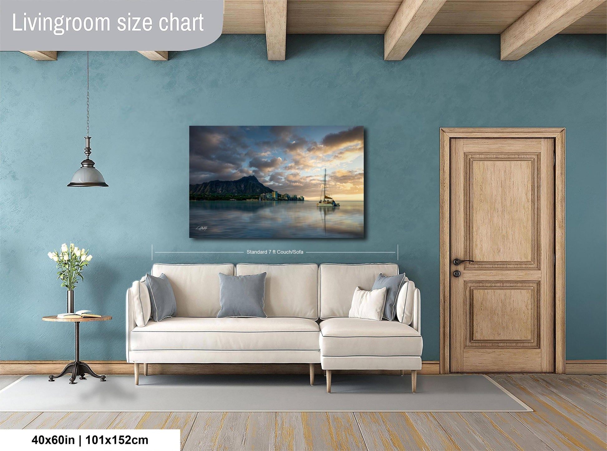 a living room with a large painting of a serene landscape hanging on the wall, featuring a boat on a lake under a cloudy sky. The painting is framed and measures 40 inches by 101.5 centimeters. The room has a white sofa, a wooden door, and a small table with a vase of flowers.