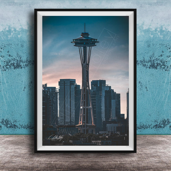 A framed photograph of the Space Needle, a famous landmark in Seattle, Washington, with the city skyline in the background.