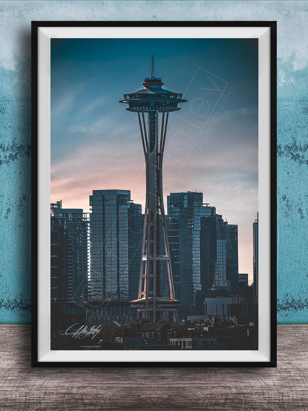 A framed photograph of the Space Needle, a famous landmark in Seattle, Washington, with the city skyline in the background.