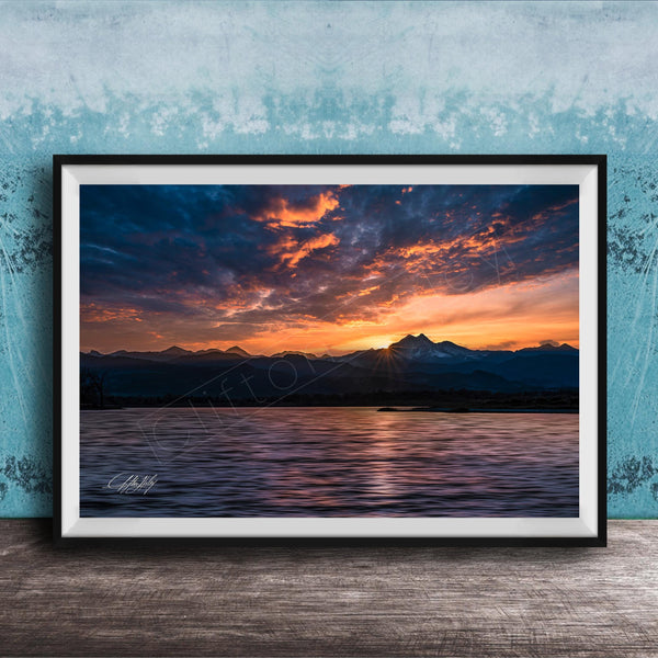 a breathtaking sunset over a mountain range, with the sun setting behind the peaks and casting a warm, golden glow across the sky.