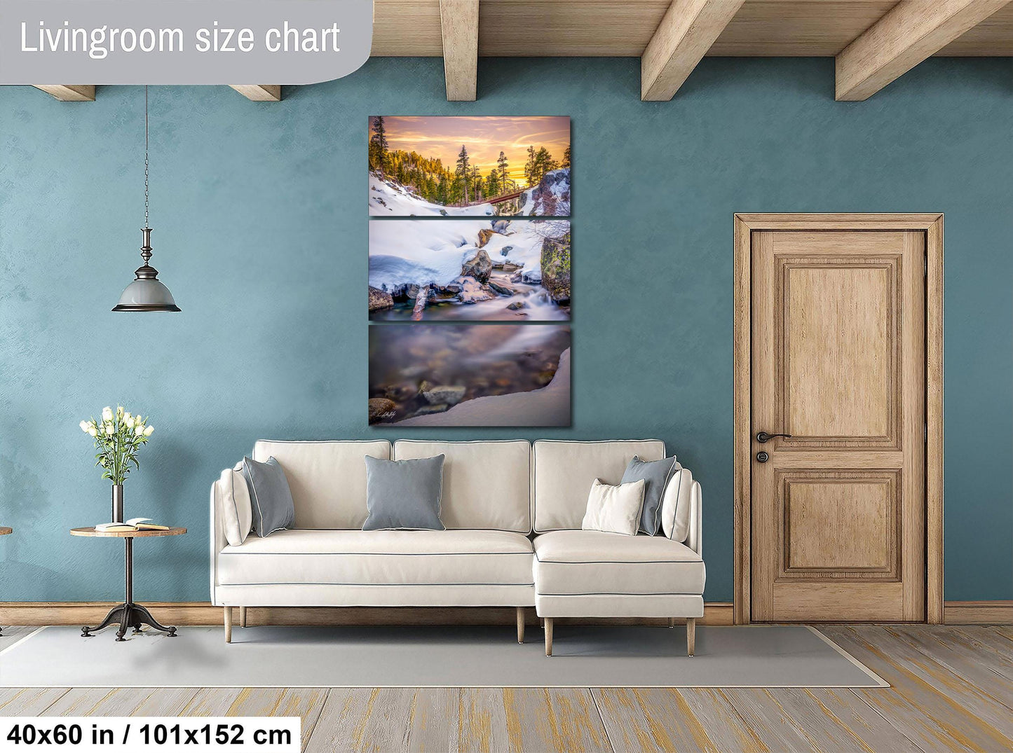 The image is a living room with a large, colorful, and detailed painting of a landscape hanging on the wall. The painting is composed of three panels, depicting a serene scene of a mountain, a river, and a sunset. The room has a white sofa, a wooden door, and a small table with a vase of flowers. The overall color scheme and composition of the painting create a harmonious and visually appealing atmosphere in the living room.