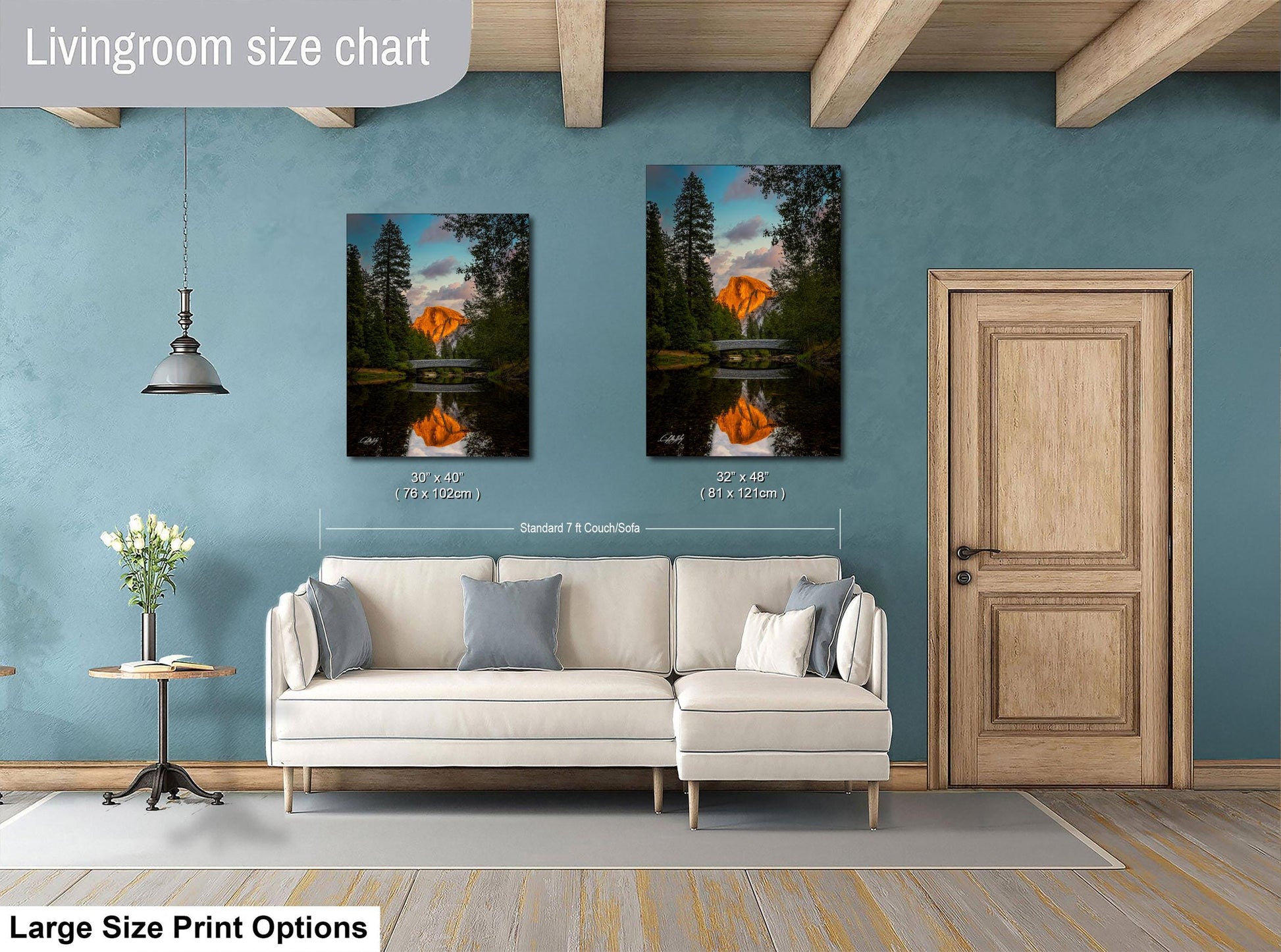 a living room with a white sofa, a wooden door, and two framed landscape paintings hanging on the wall.
