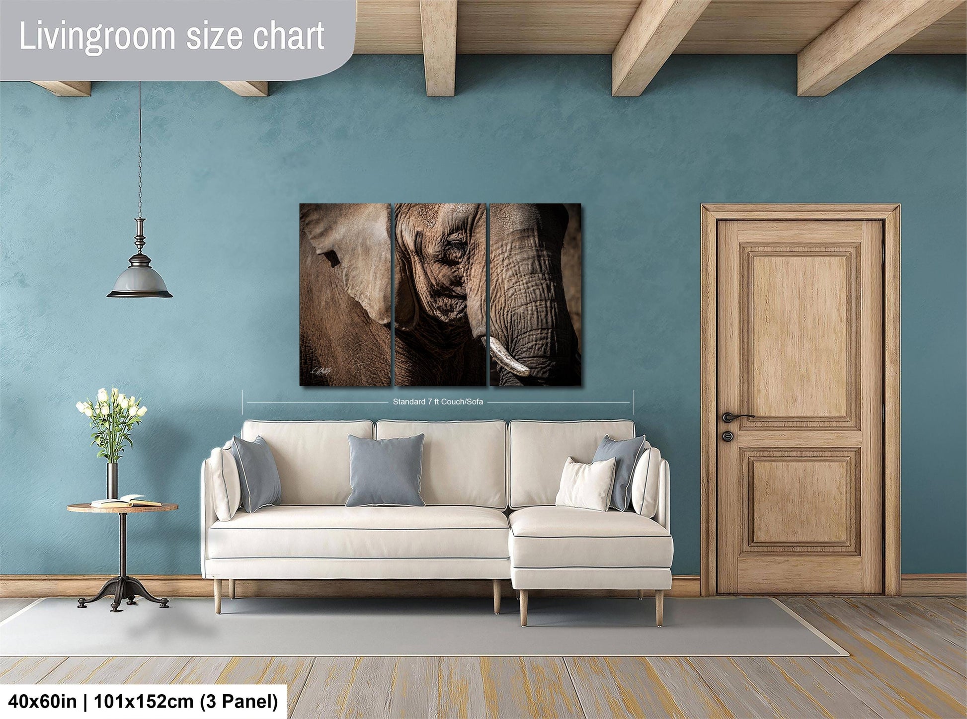 a living room with a large white sofa, a wooden door, and a painting of an elephant on the wall.