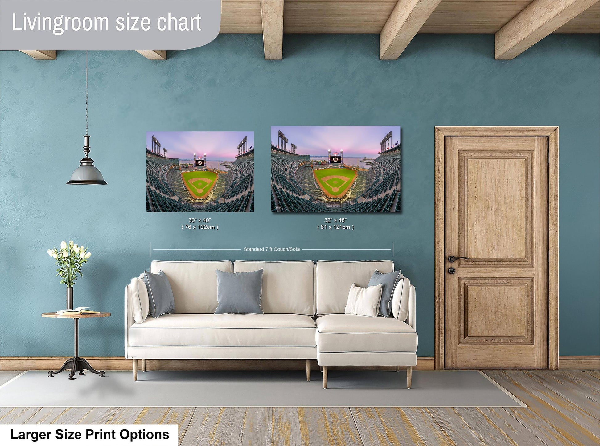 a living room with a white sofa and a wooden door. Above the sofa, there are two framed pictures of a baseball stadium, one larger than the other. The larger picture is labeled as "Larger Size Print Options" and the smaller picture is labeled as "Standard 7x7 inches".