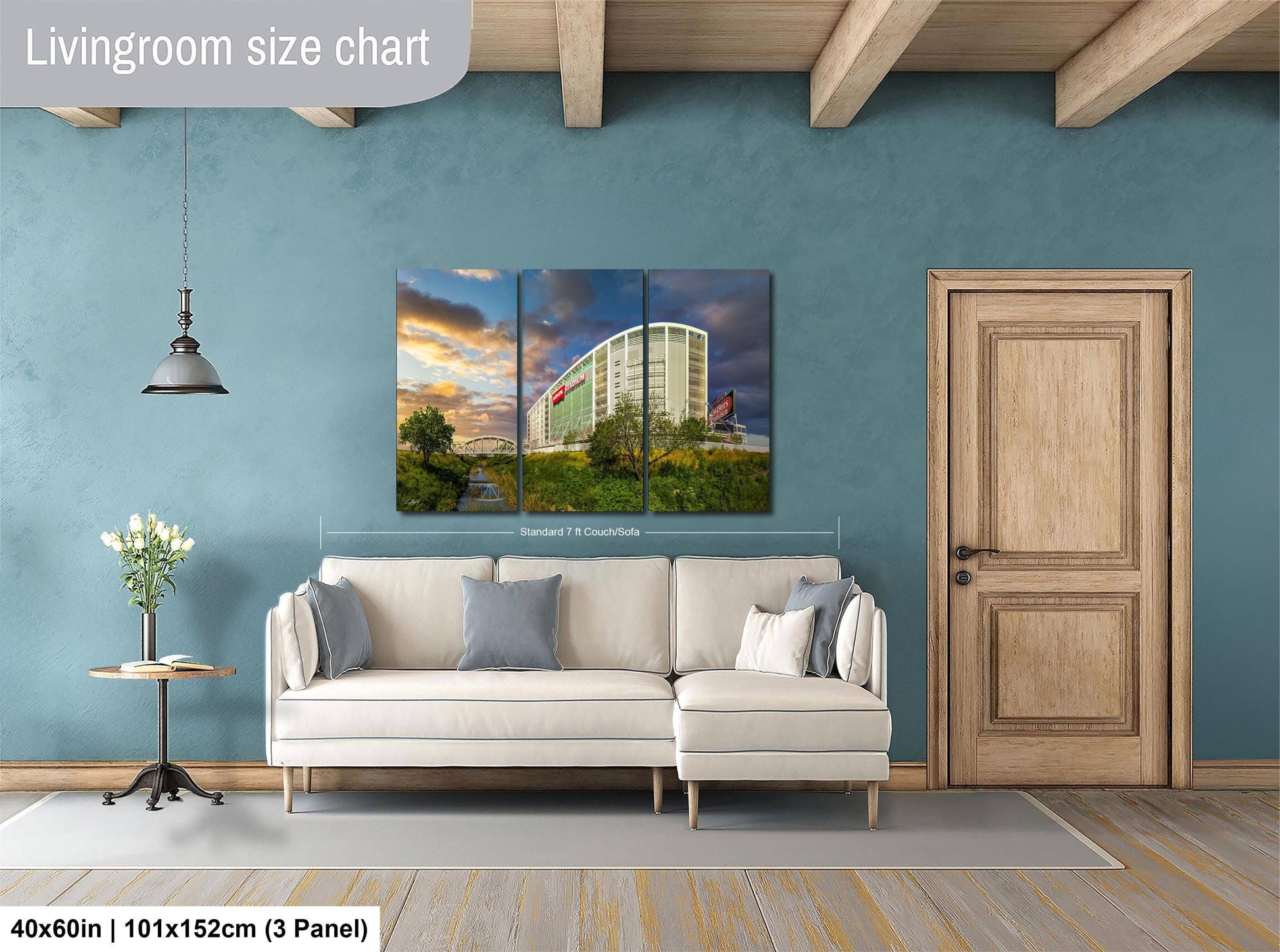 The image is a living room with a large white sofa, a wooden door, and a painting of a building on the wall.