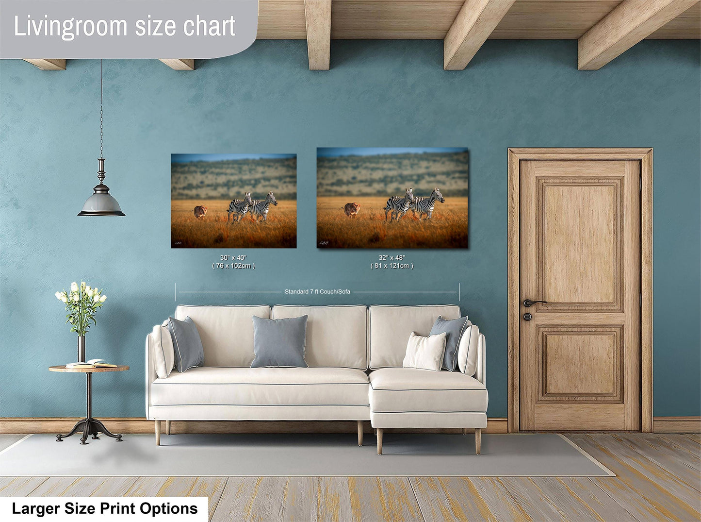 a living room with a white sofa, a wooden door, and two framed prints of zebras in a field. The prints are of different sizes, with one being larger than the other.