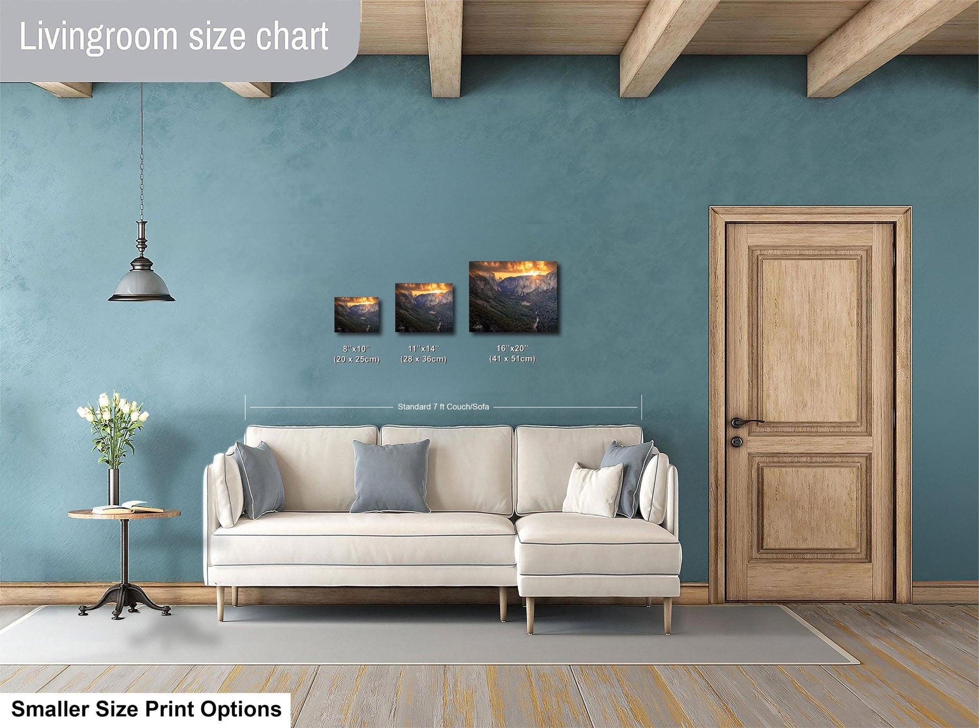 a living room with a white sofa, a wooden door, and a hanging light fixture. There are three framed pictures of landscapes displayed on the wall above the sofa.