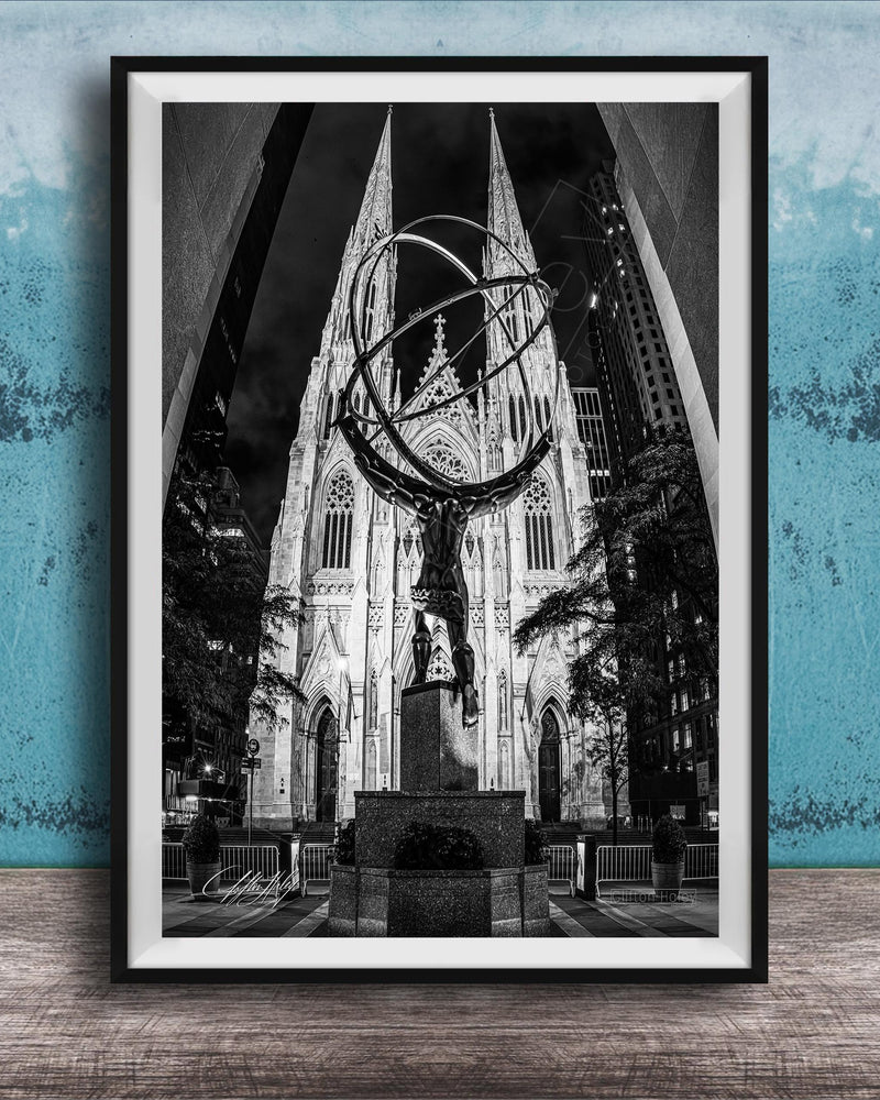 A black and white photograph of a large cathedral with a statue of a man on a pedestal in the foreground, set against a blue wall.