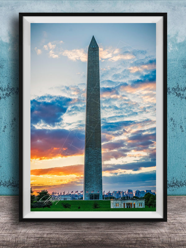 the Washington Monument, a tall obelisk, against a colorful sunset sky with clouds.