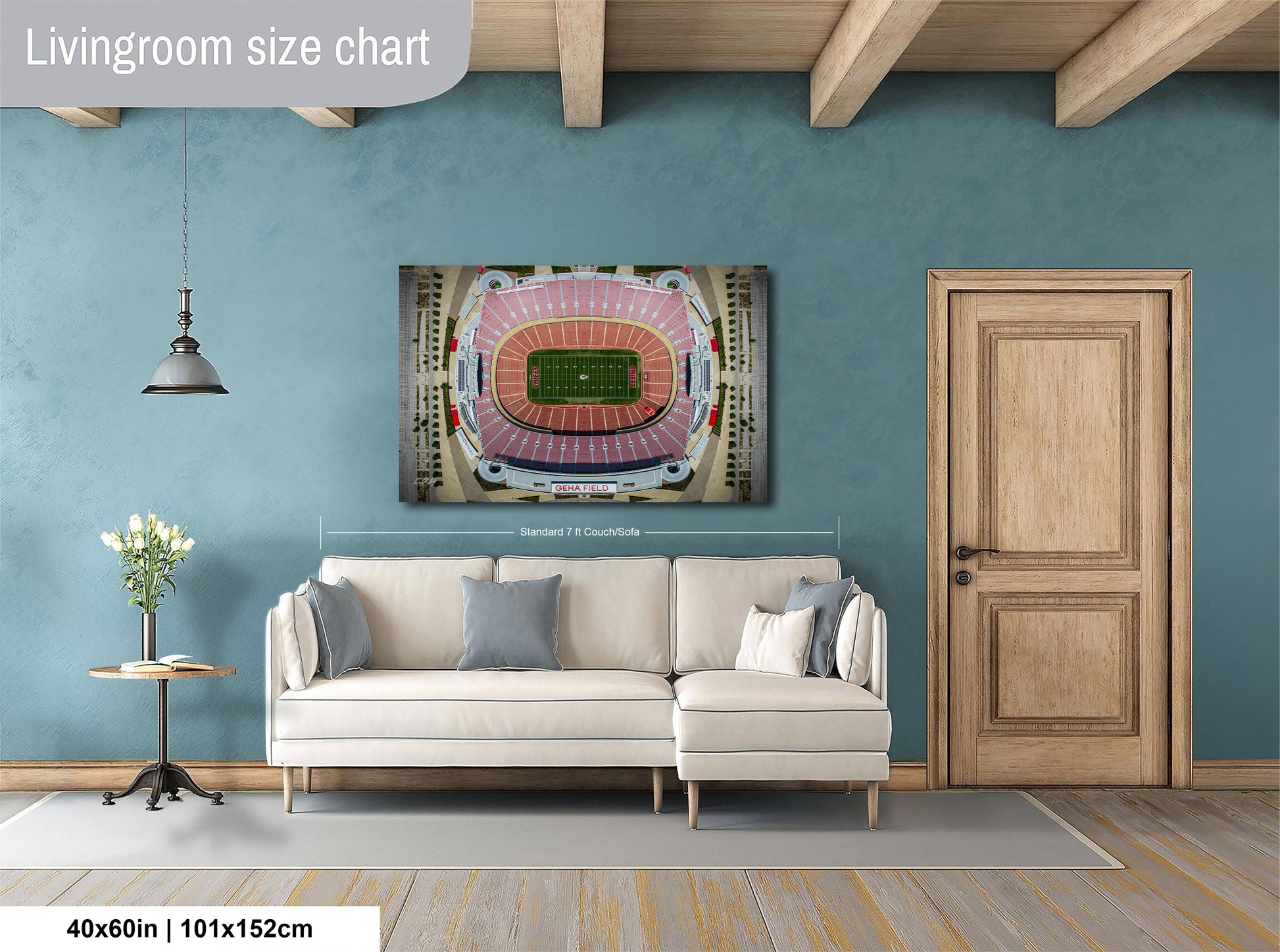 a living room with a large wall-mounted poster of a football stadium, a white sofa, a wooden door, and a small table with a vase of flowers.