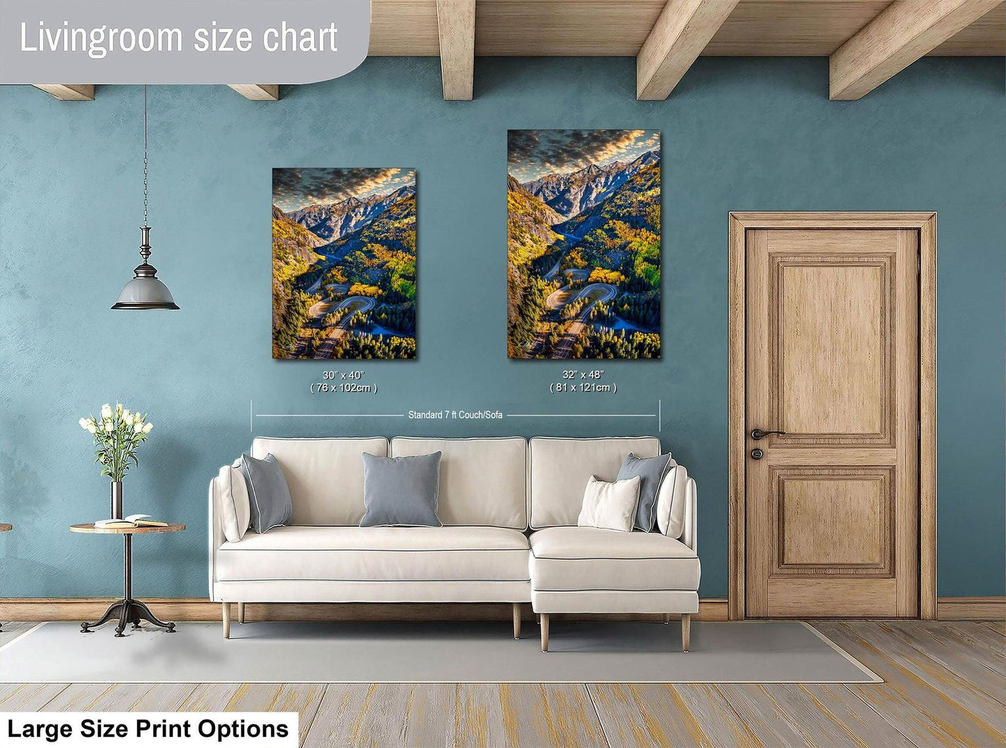 a living room with a white sofa, a wooden door, and two framed landscape paintings hanging on the wall.