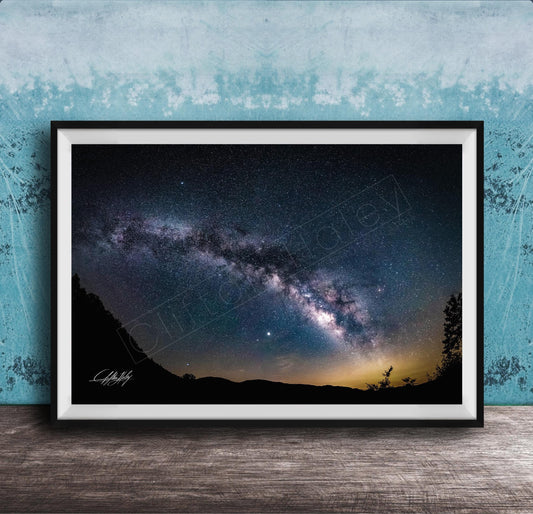 The image is a framed photograph of a night sky with a view of the Milky Way galaxy.